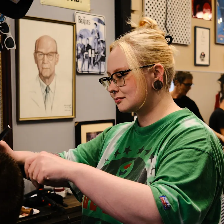 Oona leikkaamassa asiakkaan hiuksia